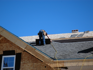 Skilled roofer meticulously installing a gable roof on a Cottontown home, showcasing their craftsmanship.